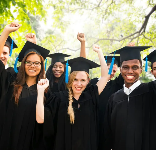 Graduates in caps and gowns cheering together