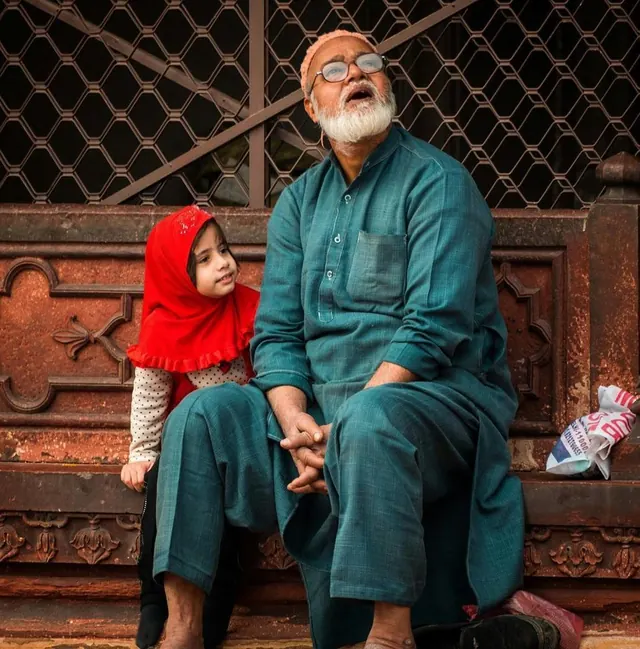 A grandfather and granddaughter sitting together
