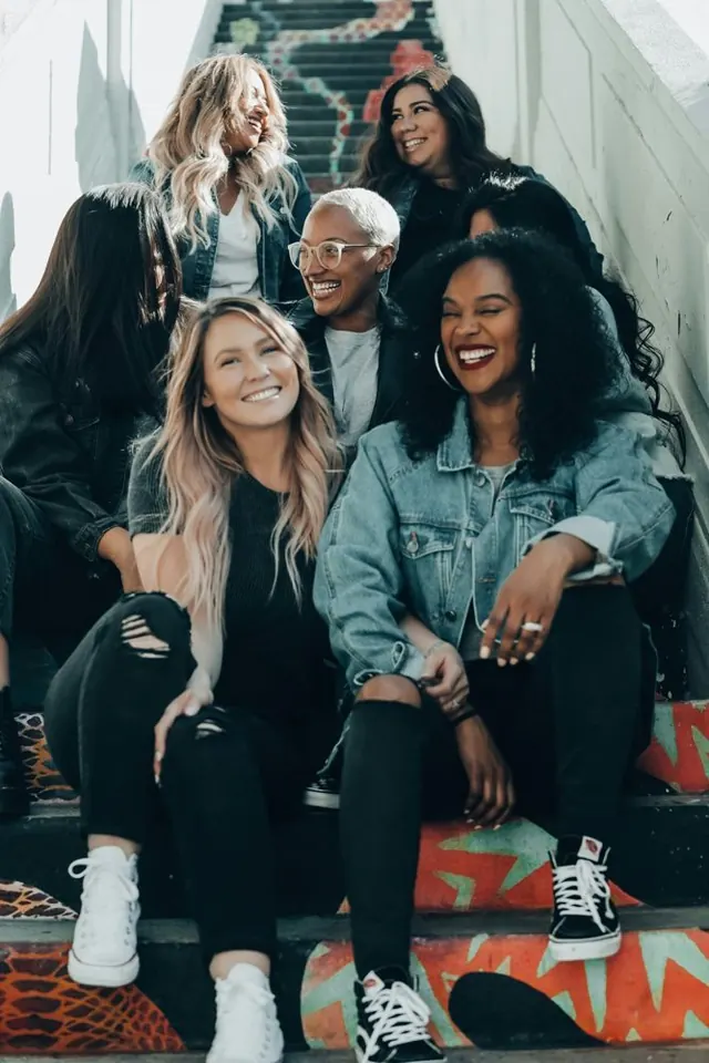 A group of friends laughing together on colorful stairs